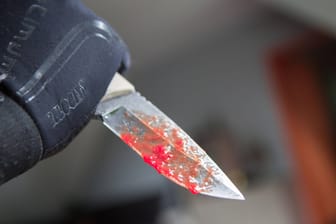 Blutiges Messer in einer Hand (Symbolbild): Ein Mann hatte in einem Bunker seine Exfreundin erstochen.