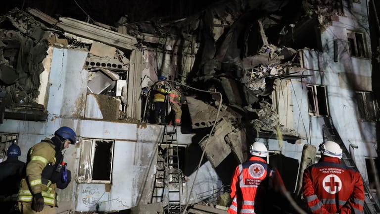 Feuerwehrleute des ukrainischen Katastrophenschutzes inspizieren ein beschädigtes Haus in Saporischschja.