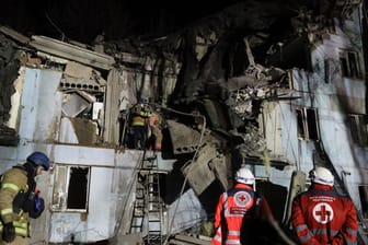 Feuerwehrleute des ukrainischen Katastrophenschutzes inspizieren ein beschädigtes Haus in Saporischschja.