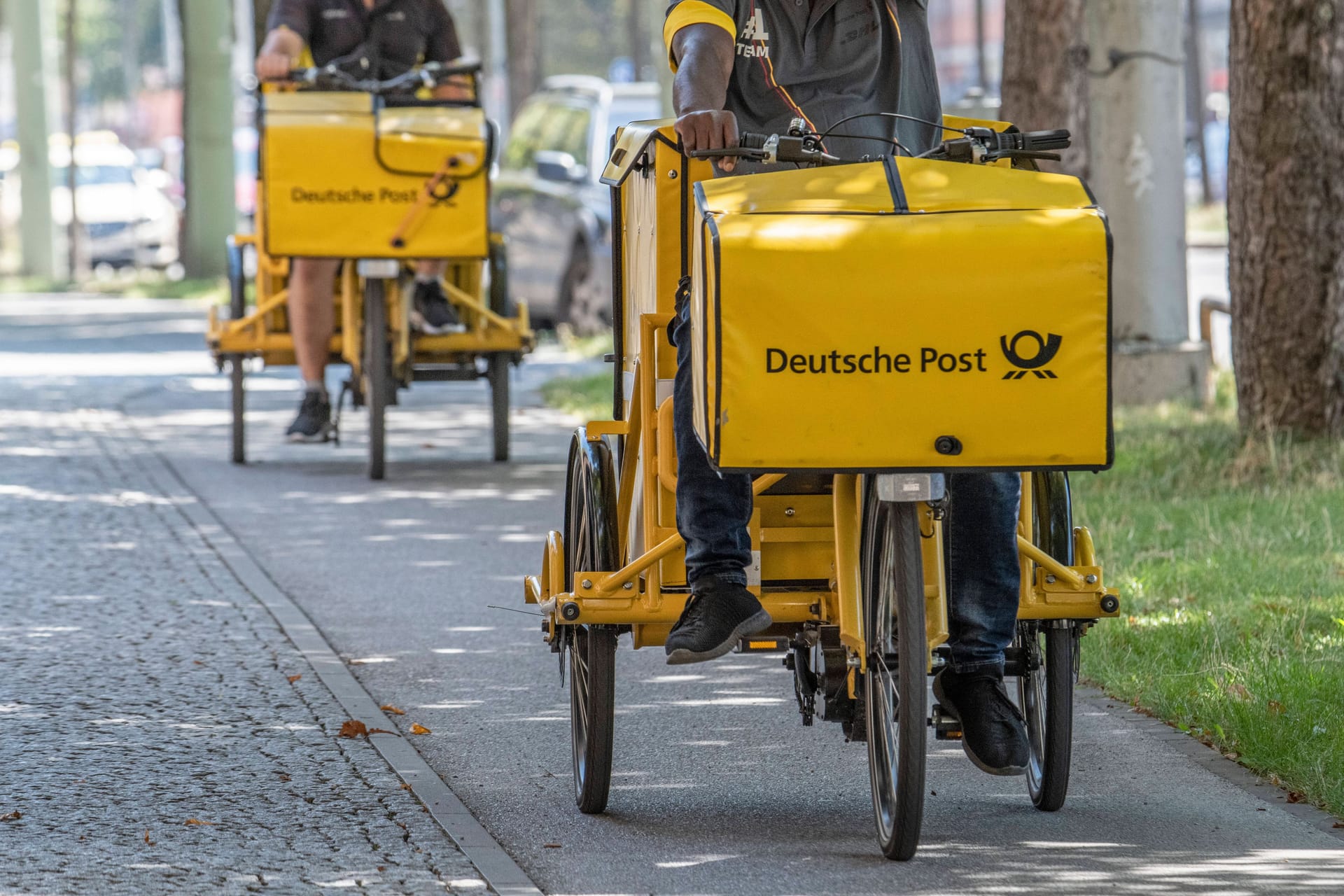 Postboten liefern die Post aus: Gewerkschaften fordern für die Mitarbeiter mehr Lohn.