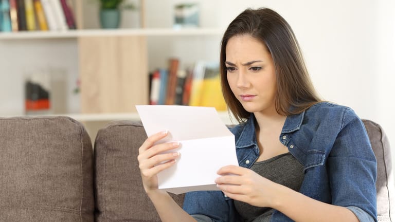 Eine Frau schaut besorgt auf ein Schreiben (Symbolbild): Ihr Vermieter darf nicht nach Belieben die Miete erhöhen.