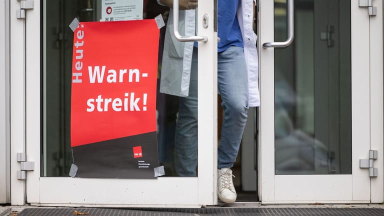 Ein Plakat mit der Aufschrift "Warnstreik" hängt an der Tür einer Klinik: In Hannover wird gestreikt.