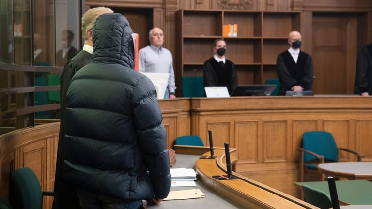 Ein Mann hält sich im Gerichtssaal eine Mappe vor das Gesicht (Archivbild): Das Landgericht Berlin hat den 25-Jährigen wegen Körperverletzung mit Todesfolge zu dreieinhalb Jahren Haft verurteilt.