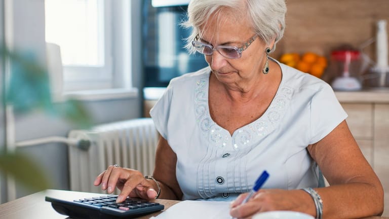 Rentnerin rechnet (Symbolbild): Steuerpflichtige müssen später selbst nachweisen, dass ihre Rente doppelt besteuert wurde.