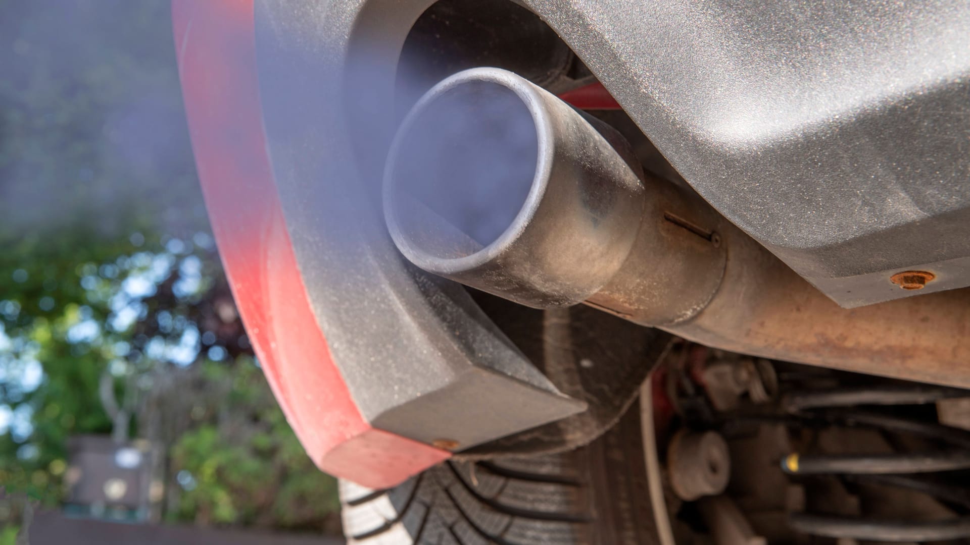 Ein alter Auspuff stößt schmutzige Abgase aus: Verbrennermotoren sollen bald der Vergangenheit angehören.