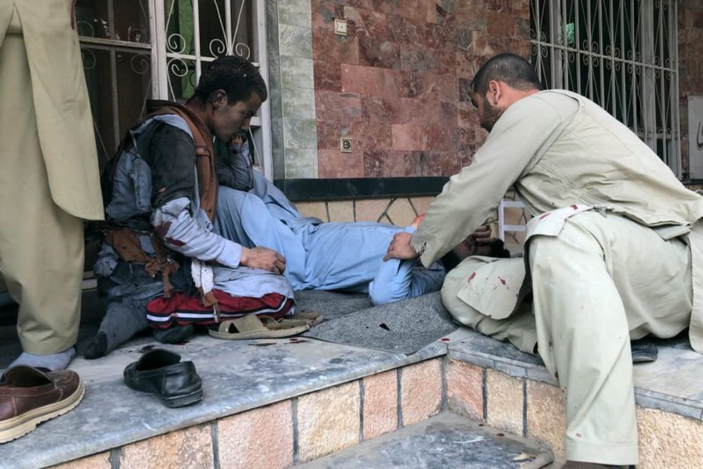 Ein verletzter Mann liegt nach einer Bombenexplosion in Mazar-e-Sharif auf dem Boden: Eine Bombe explodierte am Samstag in Afghanistan während einer Preisverleihung für Journalisten.