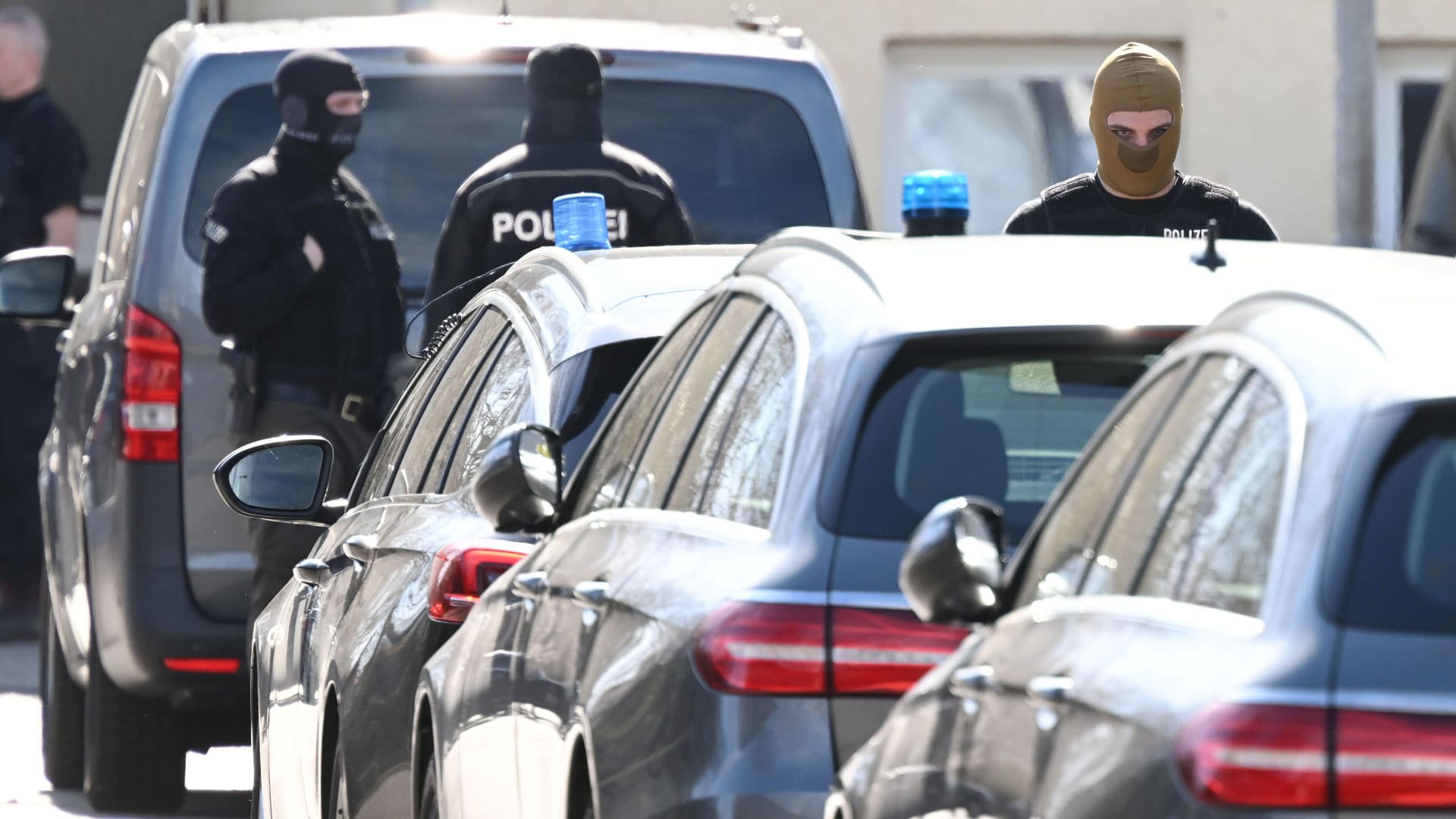 SEK-Beamte stehen zwischen Einsatzfahrzeugen in Reutlingen: Bei einer Razzia kam es zum Schusswechsel. SEK-Beamte stehen zwischen Einsatzfahrzeugen in Reutlingen: Bei einer Razzia kam es zum Schusswechsel.