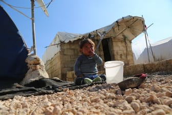 Ein kleines Kind sitzt weinend auf dem Boden im Barkhadan Camp: Im Erdbebengebiet bei Aleppo kommt kaum Hilfe an.