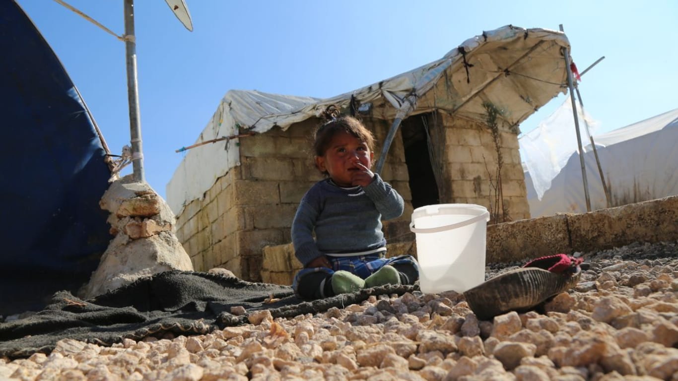 Ein kleines Kind sitzt weinend auf dem Boden im Barkhadan Camp: Im Erdbebengebiet bei Aleppo kommt kaum Hilfe an.