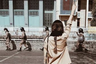 Eine junge Frau stellt sich den Regimekräften des islamischen Regimes ohne Hidschab entgegen: Im Iran riskiert sie damit verschleppt, gefoltert oder gar getötet zu werden.
