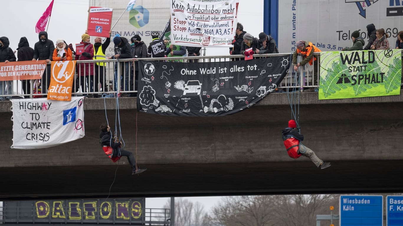Aktivisten seilen sich bei einem Protest in Frankfurt von einer Autobahnbrücke ab. Sie wollen gegen Autobahnen protestieren.