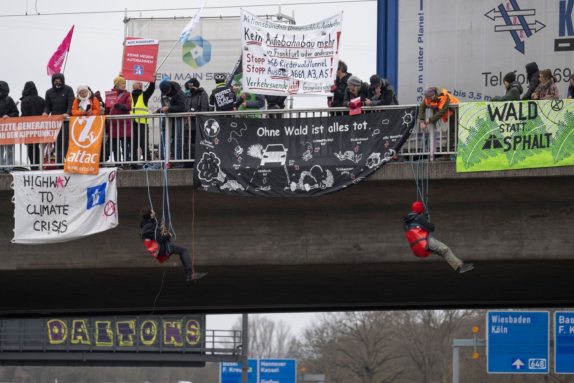 Aktivisten seilen sich bei einem Protest in Frankfurt von einer Autobahnbrücke ab. Sie wollen gegen Autobahnen protestieren.