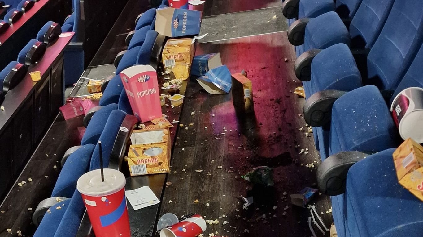 Popcorn und Getränke liegen in einer noch nicht gereinigten Reihe eines Kinosaals verstreut: Junge Leute haben in mehreren Kinos randaliert und den Abbruch der Vorführung erzwungen.