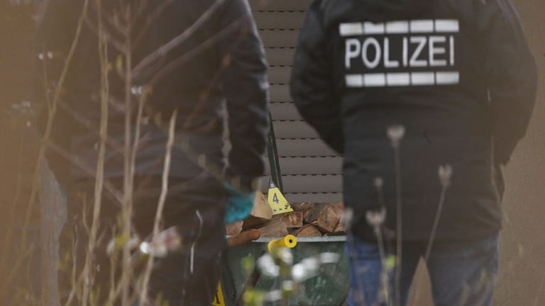Polizisten stehen am Tatort in Hattenhofen, im Hintergrund Hütchen der Spurensicherung: Die Ermittler stellen aufwendig Spuren sicher.