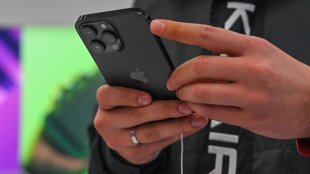 Person mit iPhone in russischem Apple-Laden: Auch in Russland ist das iPhone beliebt.
