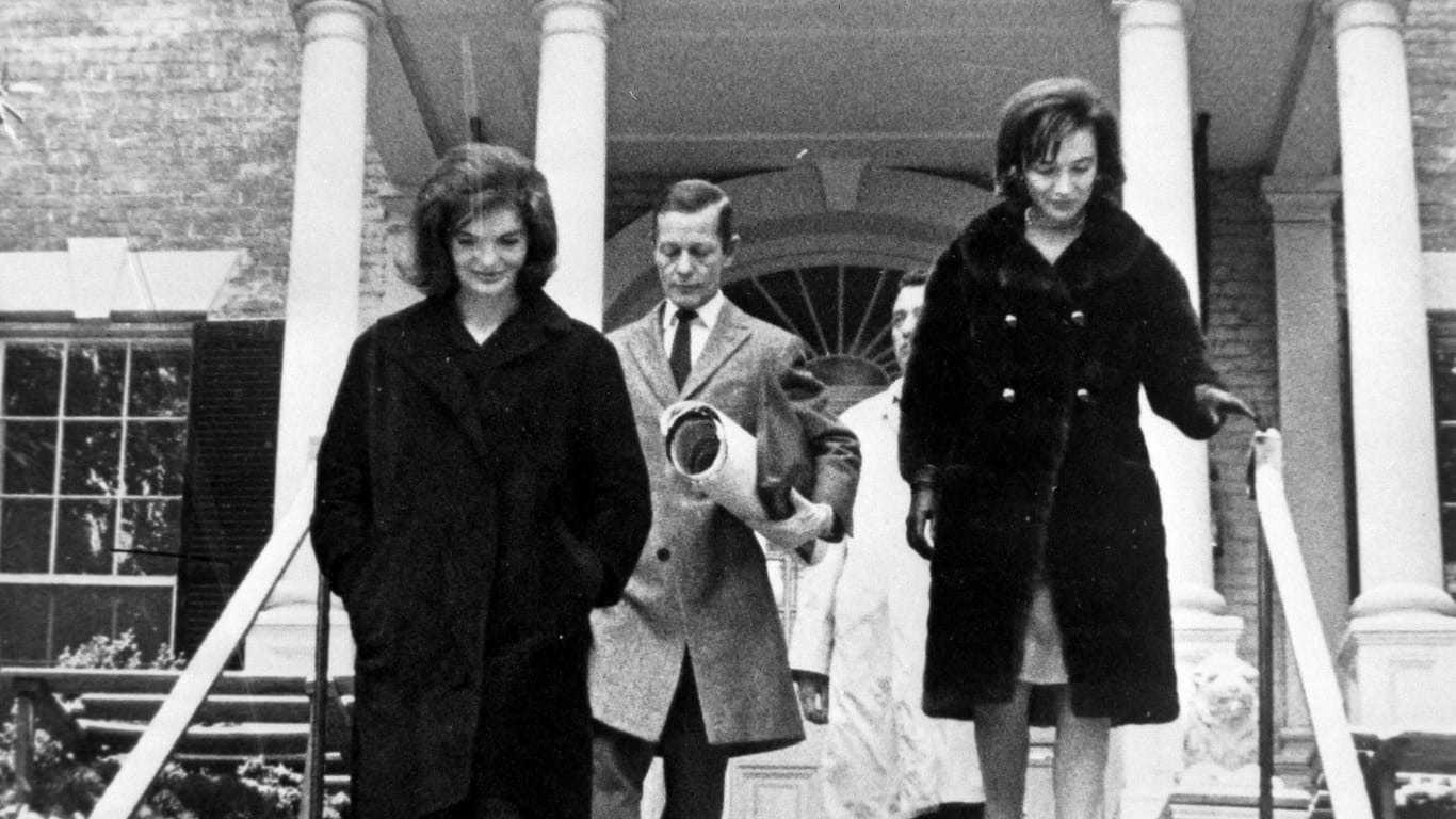 Jacqueline Kennedy (l.) und ihre Schwester Lee Radziwill verlassen das neue Haus in Georgetown.