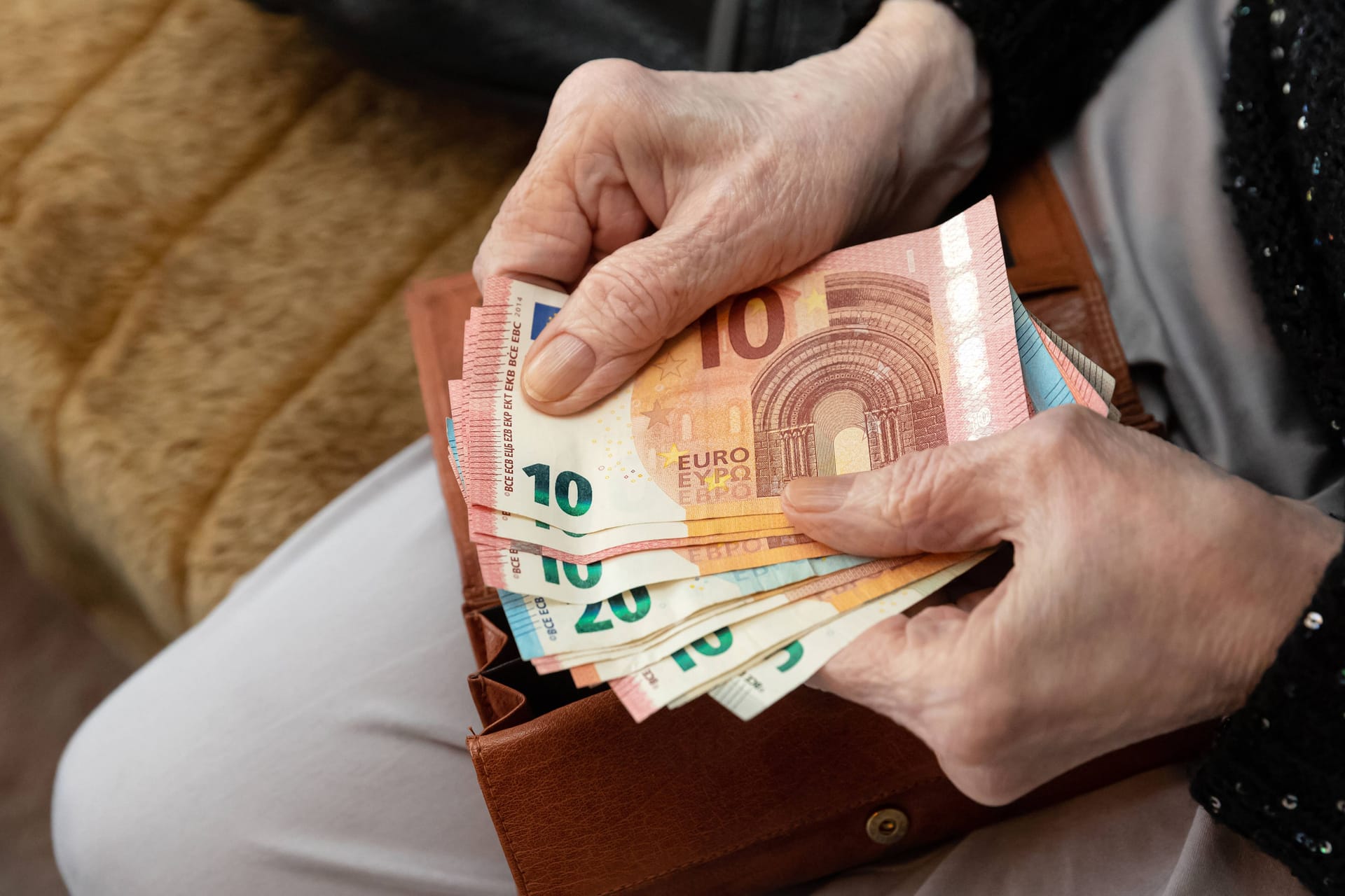 Seniorin hält Geld in der Hand (Symbolbild): Die Rentenerhöhung führt dazu, dass manche Rentner für 2023 eine Steuererklärung machen müssen.