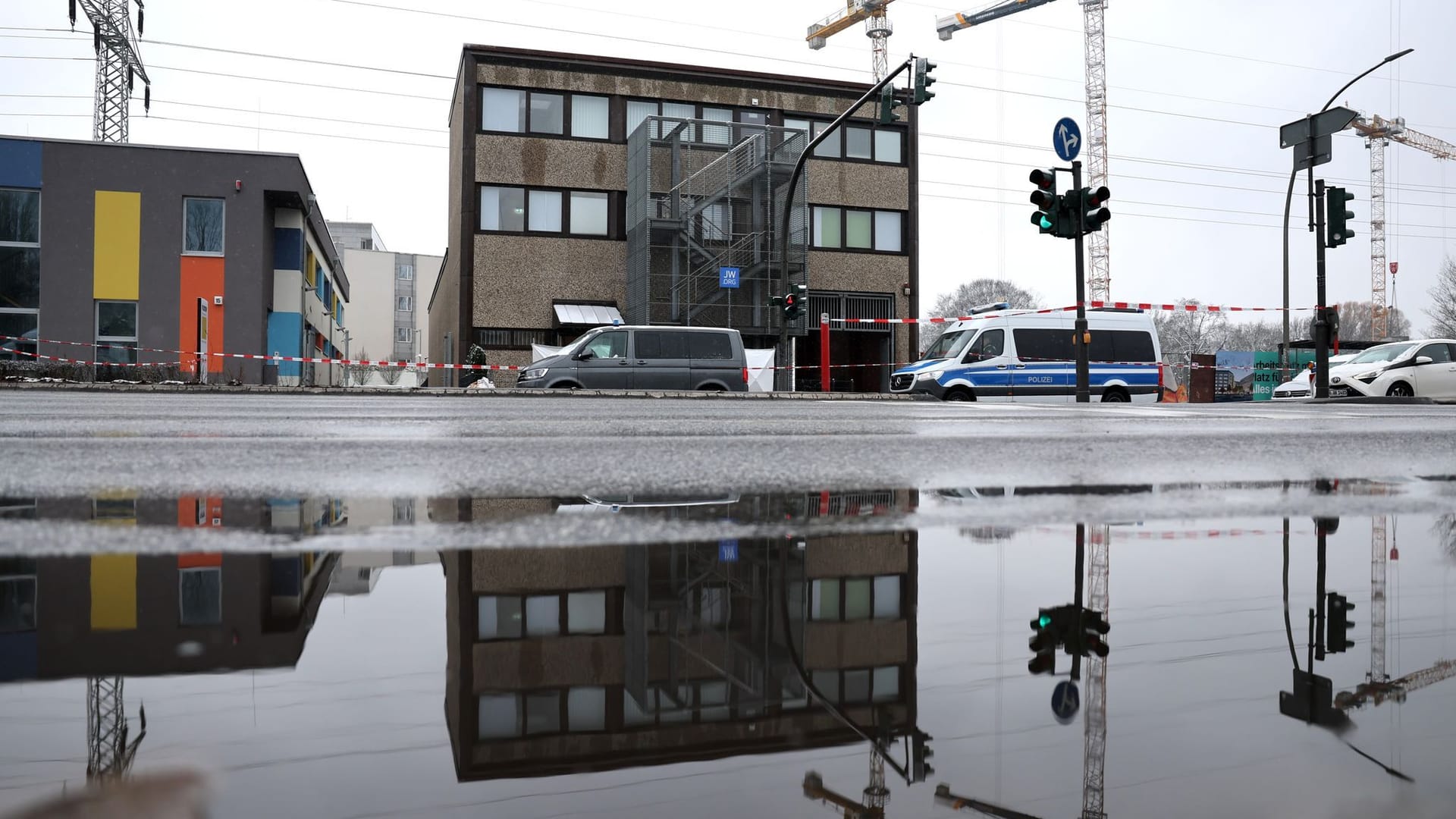 Einsatzfahrzeuge der Polizei und der Spurensicherung stehen vor dem Versammlungsgebäude der Zeugen Jehovas im Stadtteil Alsterdorf.