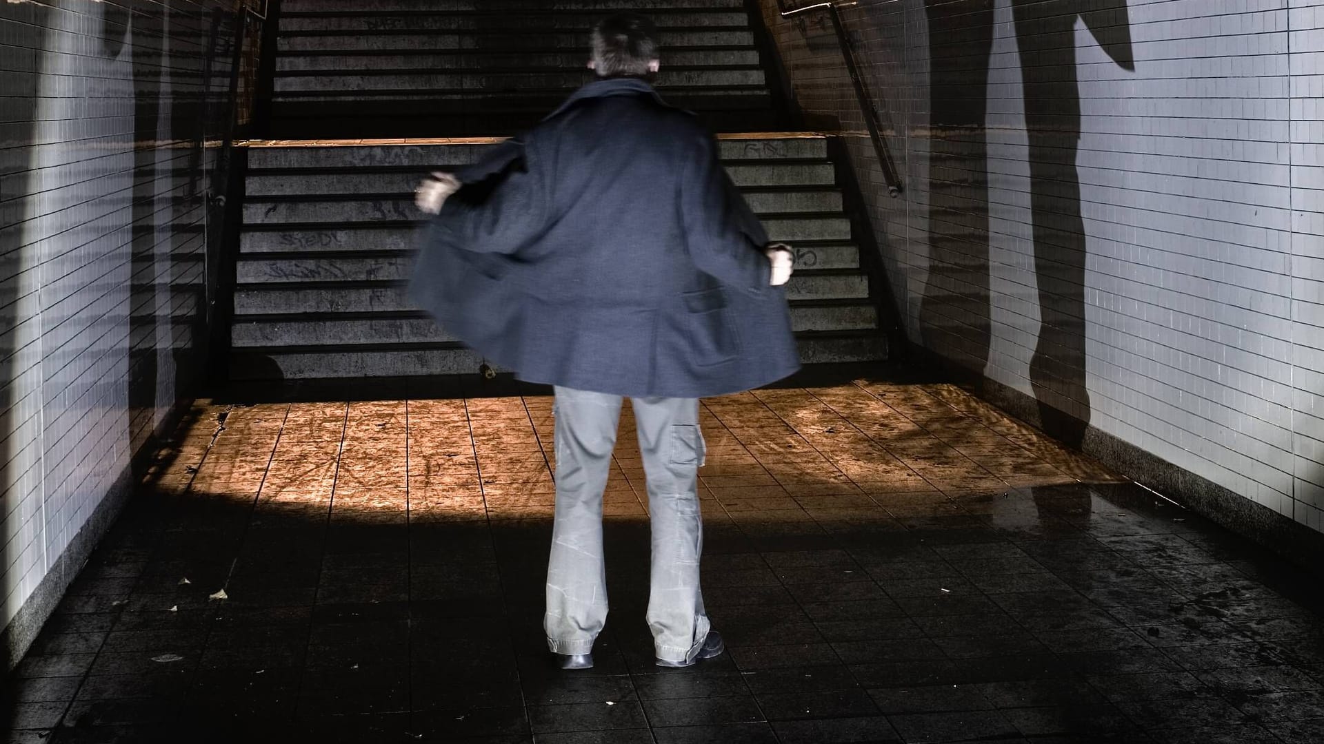 Ein Mann steht in einem Tunnel und öffnet seine Jacke (Symbolbild): Der Quickborner räumte seine Taten schnell ein.