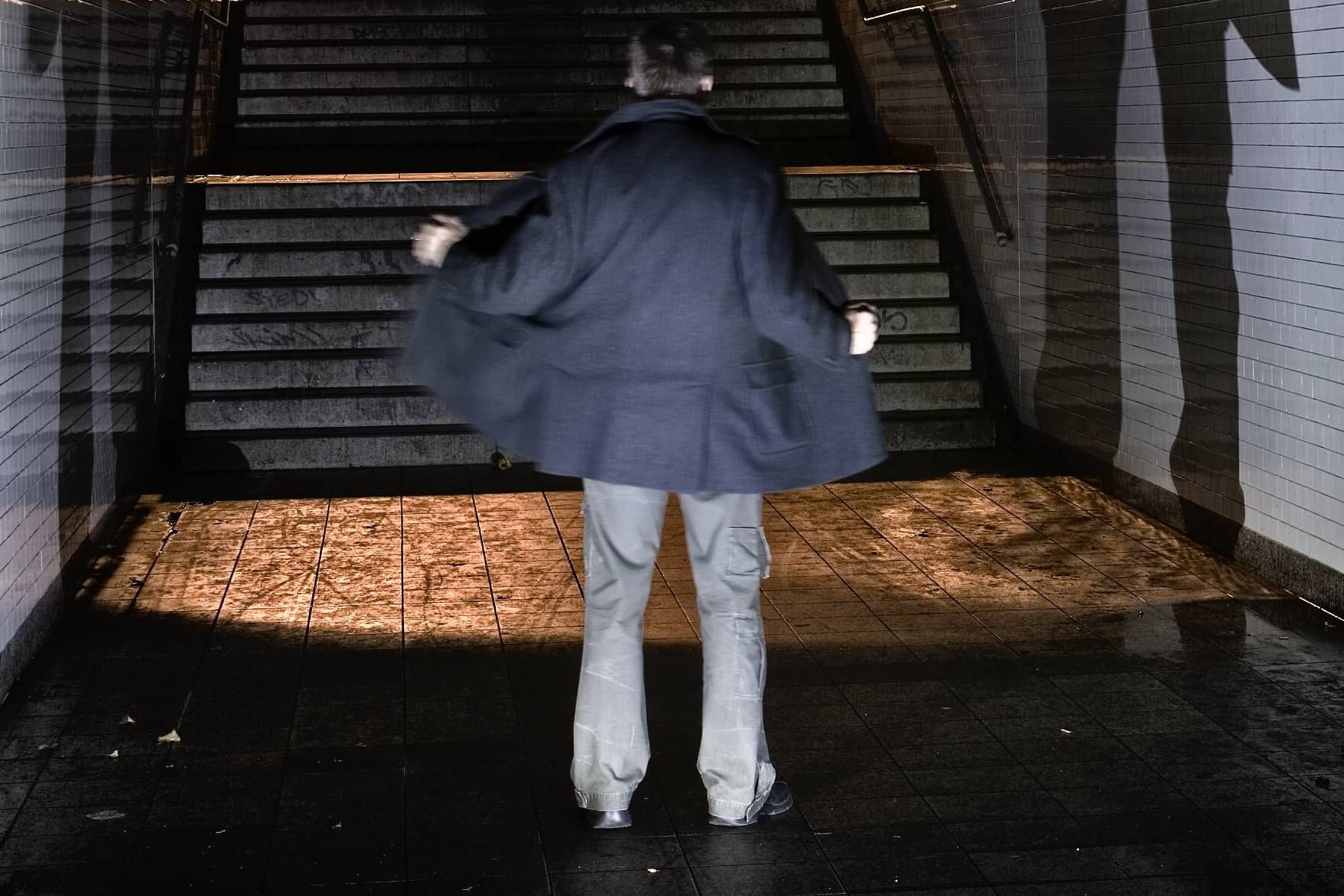 Ein Mann steht in einem Tunnel und öffnet seine Jacke (Symbolbild): Der Quickborner räumte seine Taten schnell ein.