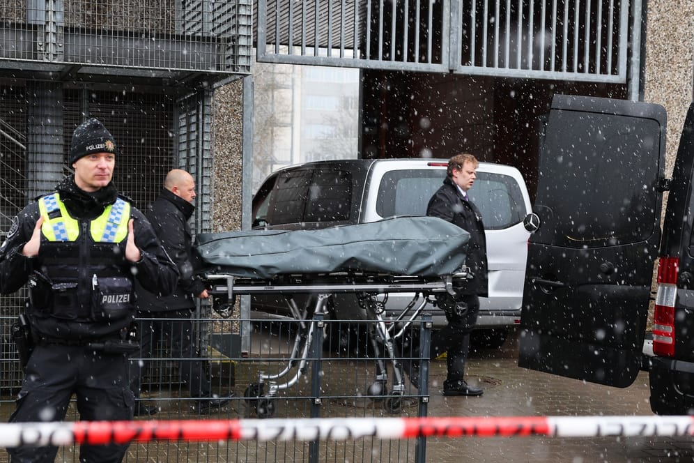 Bestatter bringen eine abgedeckte Bahre zu ihrem Fahrzeug am Gebäude der Zeugen Jehovas im Stadtteil Alsterdorf. Insgesamt kamen bei der Tat laut Polizei acht Menschen ums Leben.