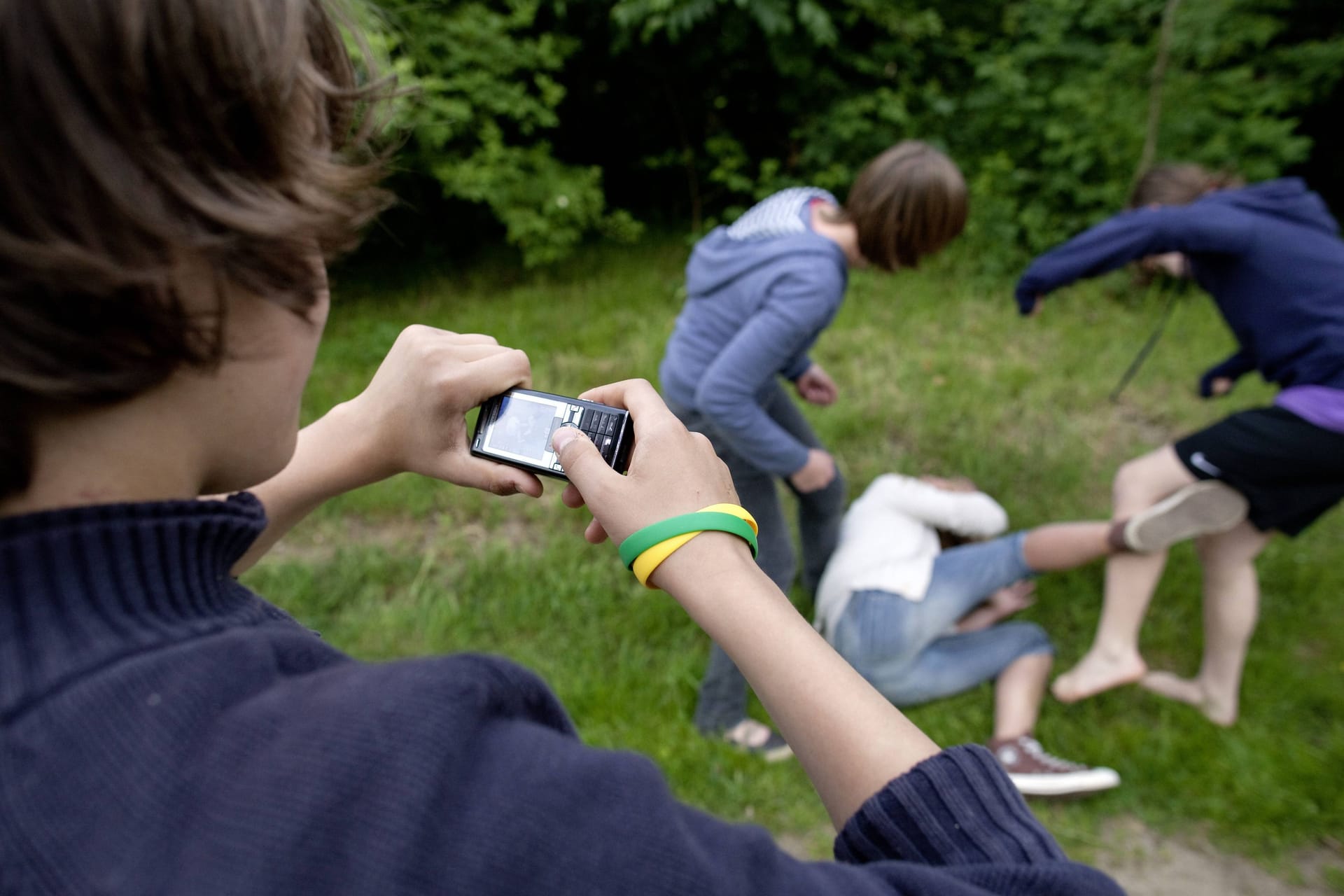 Jugendlicher filmt mit dem Handy, wie ein Mädchen verprügelt wird (Symbolbild): In Heide wurde eine 13-Jährige von anderen Jugendlichen misshandelt.