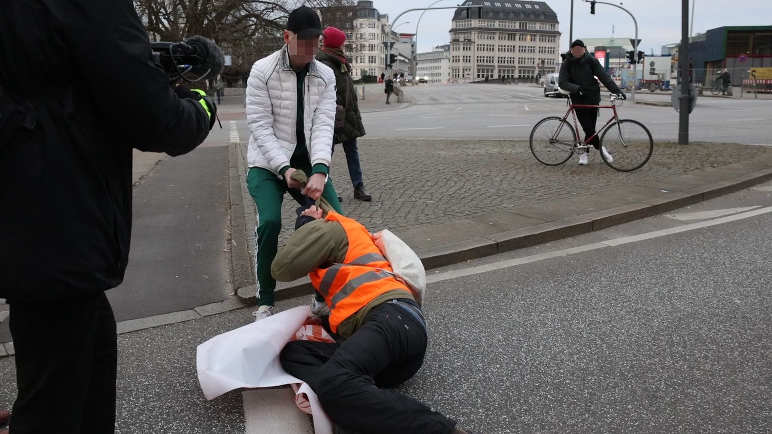 Ein Mann zieht einen Aktivisten von der Straße am Glockengießerwall: Es blieb nicht nur bei einem Vorfall. Ein Mann zieht einen Aktivisten von der Straße am Glockengießerwall: Es blieb nicht nur bei einem Vorfall.