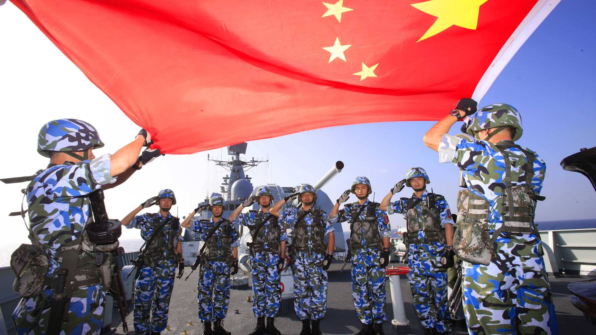 Chinesische Soldaten halten eine Flagge vor einem Zerstörer hoch (Archivbild): Peking will bei den Verteidigungsausgaben kräftig zulegen.