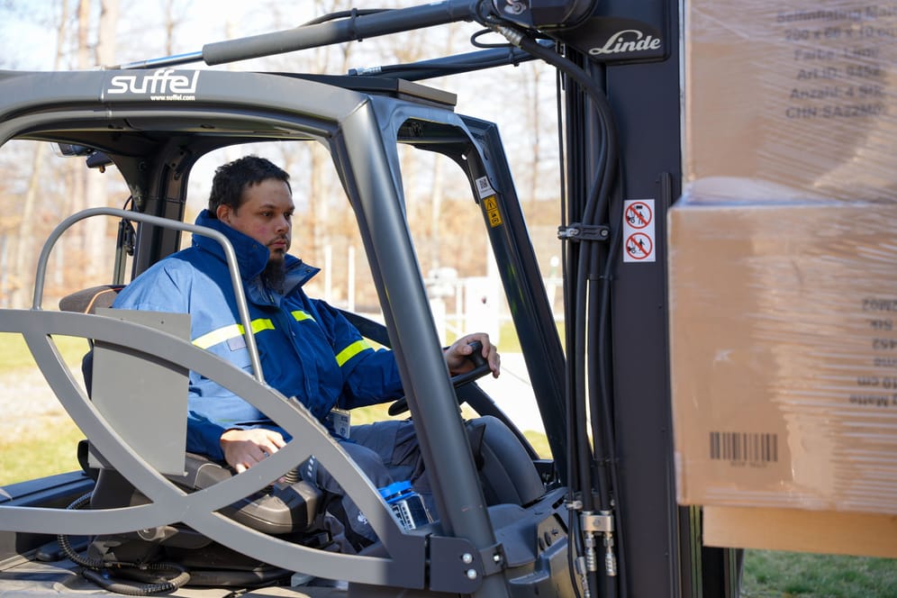 Ein THW-Mitarbeiter verlädt mit einem Gabelstapler Material auf einen Lastwagen (Symbolbild).