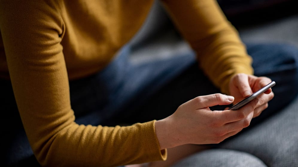 Eine Jugendliche hält ein Smartphone in den Händen (Symbolbild): Jugendliche haben eine 13-Jährige misshandelt und die Tat mit dem Handy gefilmt.
