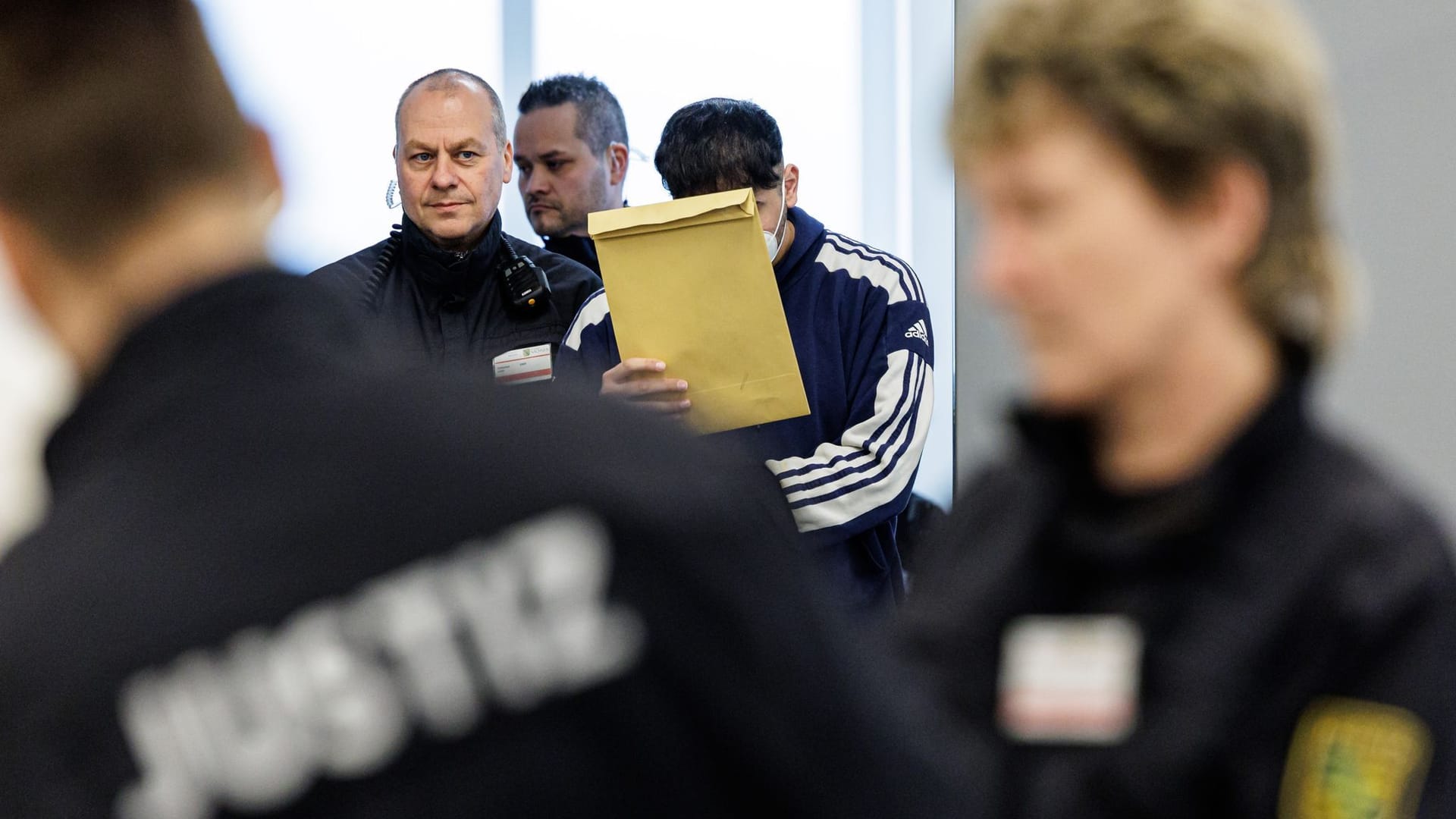 Angeklagte Abdul Majed R. (r) wird von Justizbeamten in Handschellen in den Gerichtssaal des Oberlandesgerichts Dresden geführt. Seit Ende Januar wird gegen insgesamt sechs junge Männer wegen schweren Bandendiebstahls, Brandstiftung und besonders schwerer Brandstiftung verhandelt.