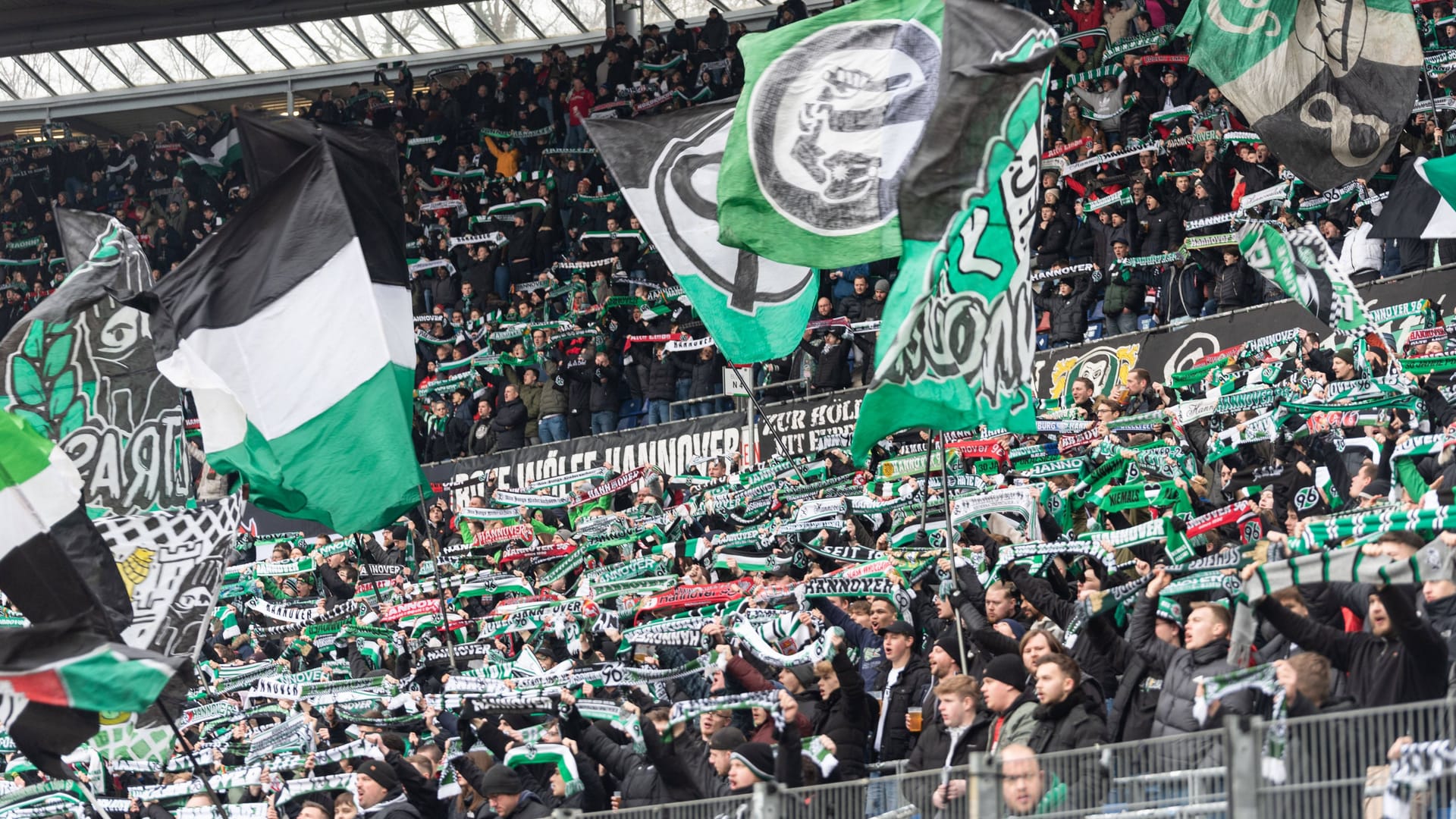 Fans von Hannover 96 halten in der Nordkurve ihre Schals hoch (Archivbild): Zum Heimspiel gegen Rostock erwartet die Polizei Verkehrsbehinderungen.