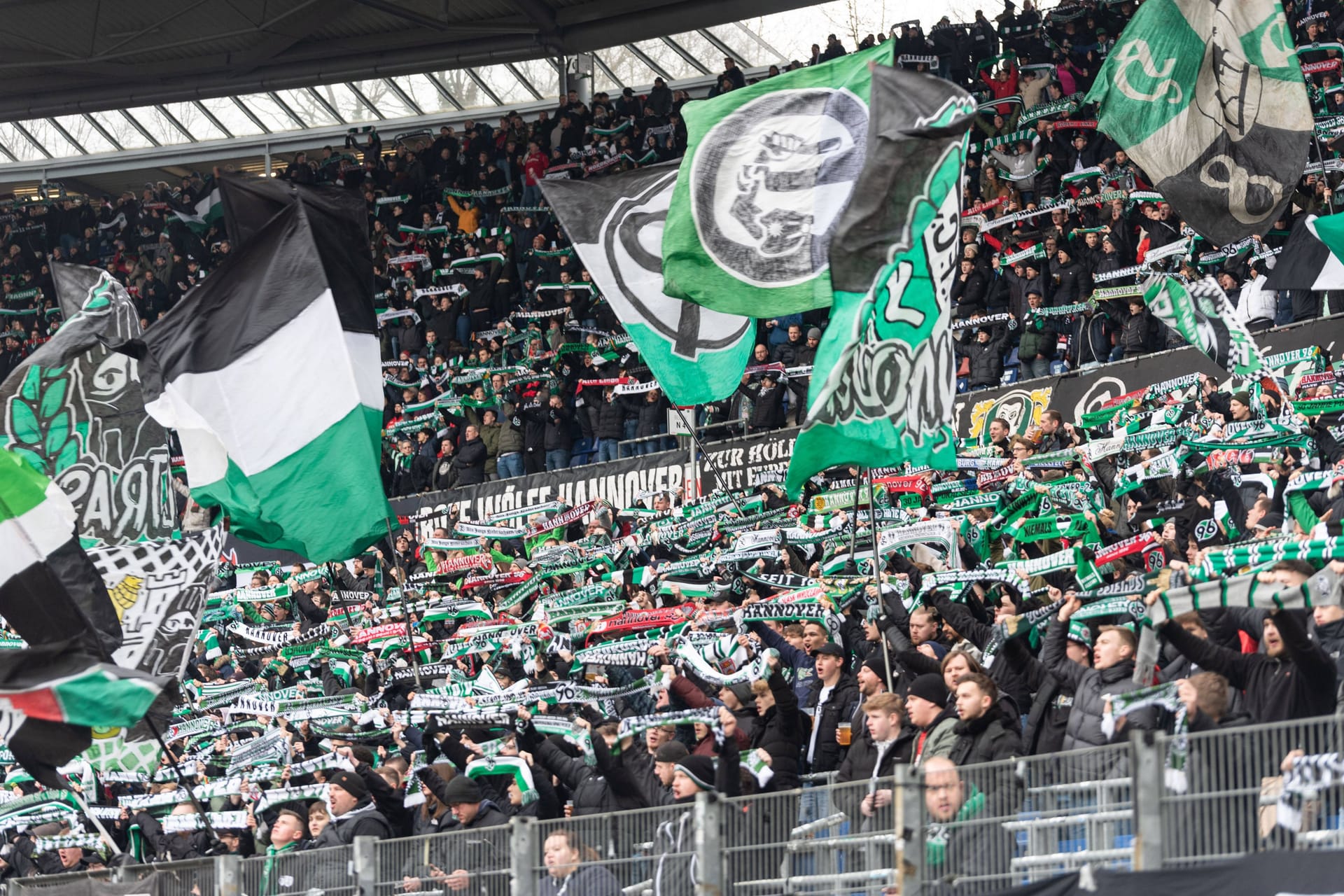 Fans von Hannover 96 halten in der Nordkurve ihre Schals hoch (Archivbild): Zum Heimspiel gegen Rostock erwartet die Polizei Verkehrsbehinderungen.