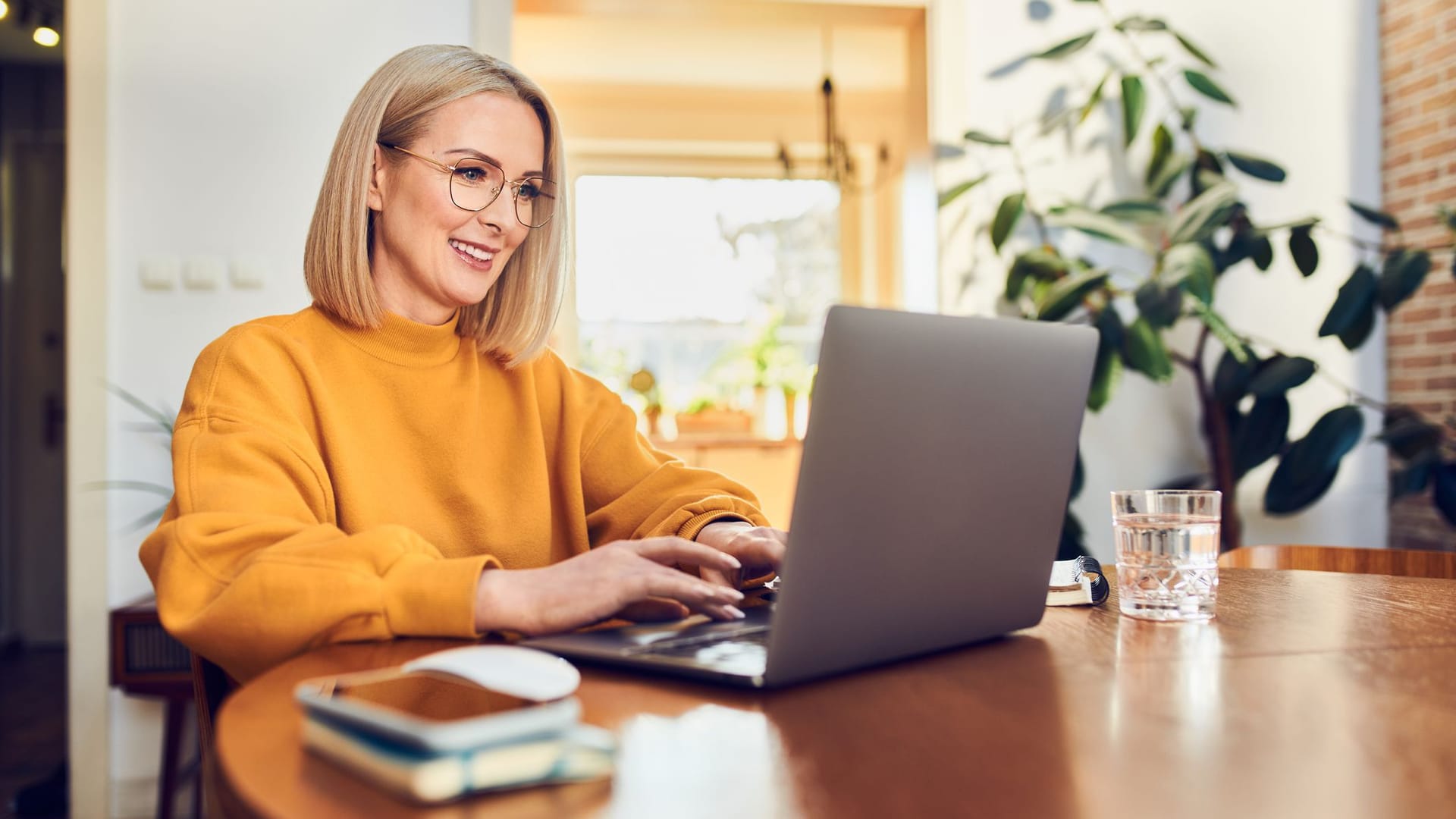 Eine Frau arbeitet zu Hause am Laptop (Symbolbild): Selbstständige können ihre Rente mit freiwilligen Beiträgen aufstocken.