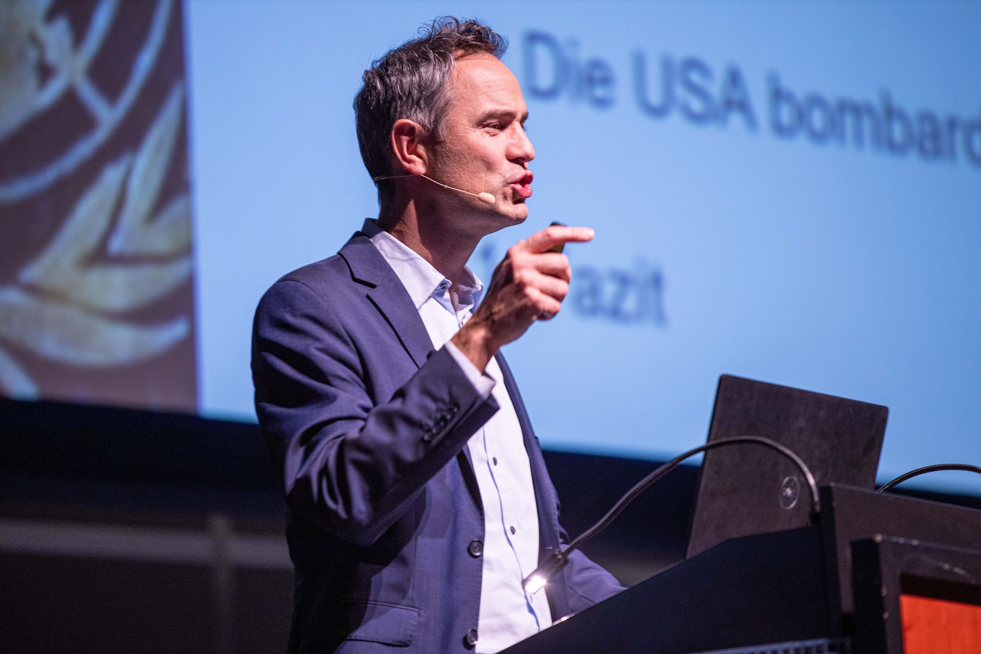 Daniele Ganser bei einem Vortrag 2019 in Karlsruhe: Auf der Leinwand im Hintergrund wird sein Lieblingsthema behandelt: die USA.