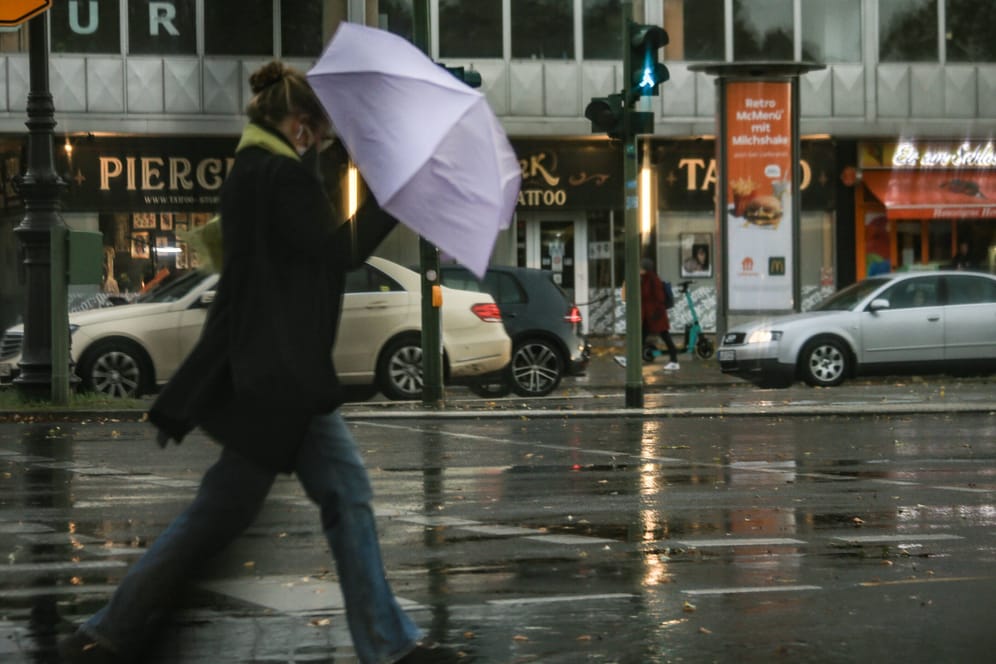 Eine Frau mit Regenschirm (Archivbild): In Berlin und Brandenburg wird es stürmisch.
