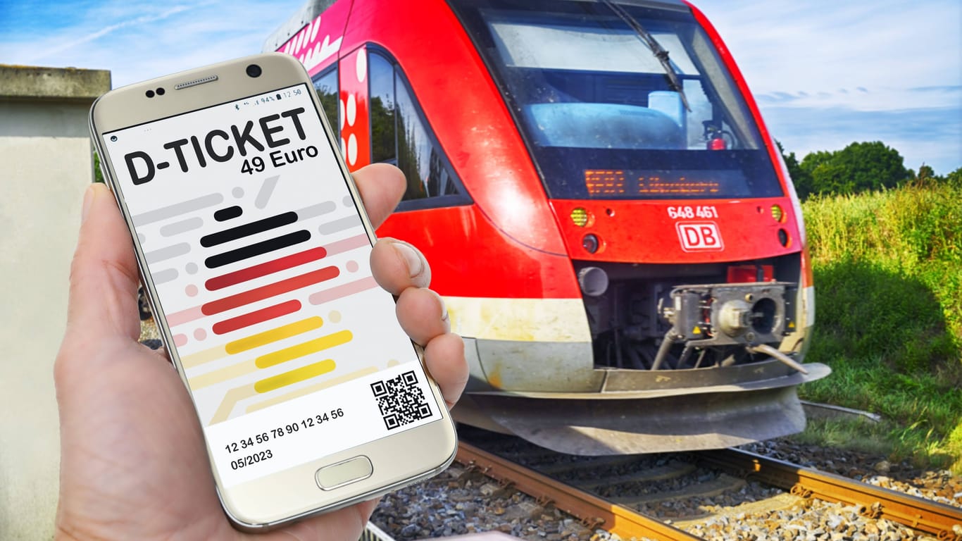 Hand hält ein Smartphone mit D-Ticket, Deutschlandticket vor einer Regionalbah