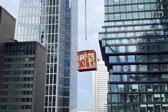 Frankfurt: Mit einer Krangondel wird der verletzte Bauarbeiter nach unten gebracht.