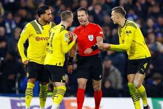 Dortmund sauer: Emre Can, Marco Reus und Nico Schlotterbeck (v.l.) diskutieren nach der Elfer-Entscheidung mit Schiedsrichter Danny Makkelie.