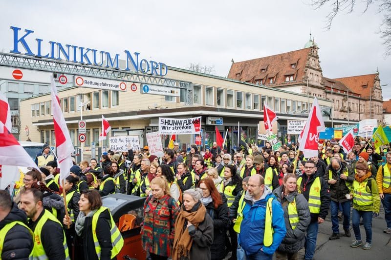 Klinik-Beschäftigte aus ganz Bayern gehen vor dem Klinikum Nord in Nürnberg auf die Straße, um für bessere Arbeitsbedingungen einzustehen.