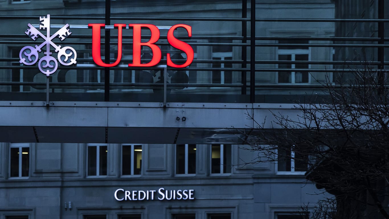 Die Logos der Schweizer Banken Credit Suisse und UBS sind auf verschiedenen Gebäuden in Zürich zu sehen. Die deutlich größere UBS wird den kleineren Konkurrenten übernehmen.