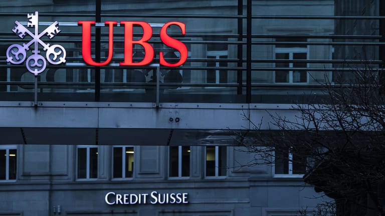 Die Logos der Schweizer Banken Credit Suisse und UBS sind auf verschiedenen Gebäuden in Zürich zu sehen. Die deutlich größere UBS wird den kleineren Konkurrenten übernehmen.