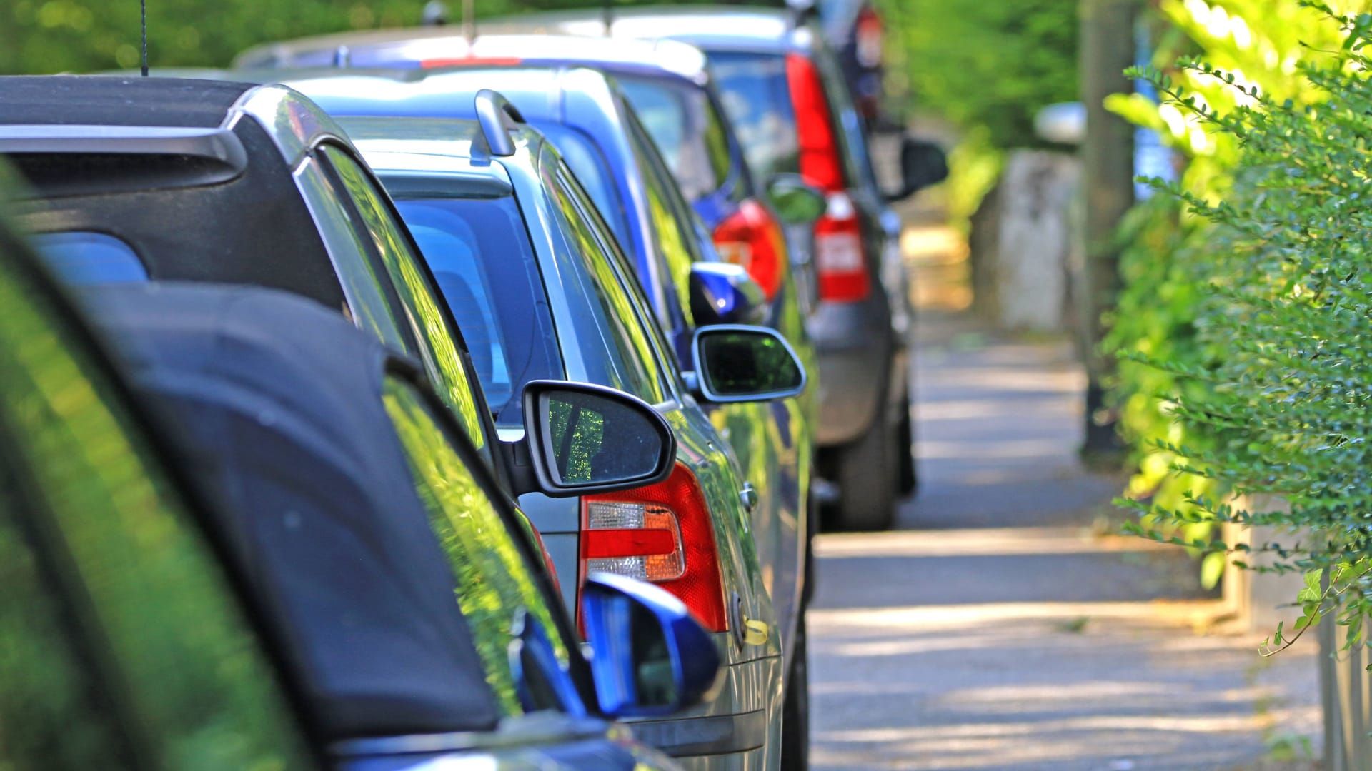 Aufgesetzt geparkte Autos in einer Straße (Symbolfoto): Der jahrelange Streit geht zur nächsten Instanz.