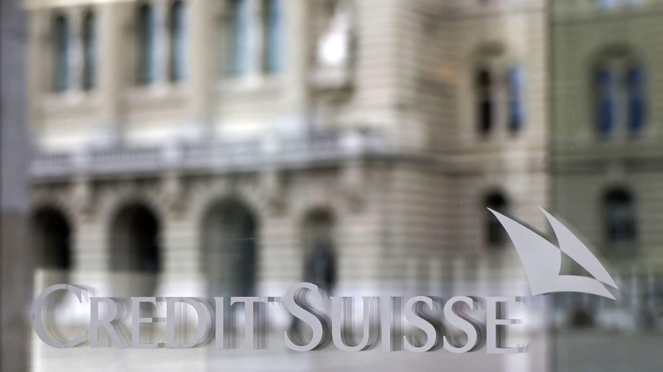 Das Bundeshaus in Bern spiegelt sich in einem Fenster einer Filiale der Credit Suisse. Nach zähen Verhandlungen steht die Übernahme durch die UBS nun fest.