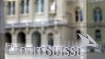 The Federal Palace in Bern is reflected in a window of a Credit Suisse branch.  After tough negotiations, the takeover by UBS is now certain.