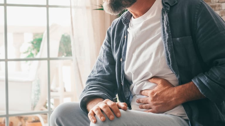 Mann mit Bauchschmerzen links: Eine chronische wiederkehrende Divertikulitis kann immer wieder akute Beschwerden hervorrufen.