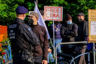 Zum Prozess-Auftakt stehen Polizisten vor Beginn eines Prozesses gegen eine Frau und drei Männer vor dem Oberlandesgericht (OLG) Dresden vor Demonstranten.