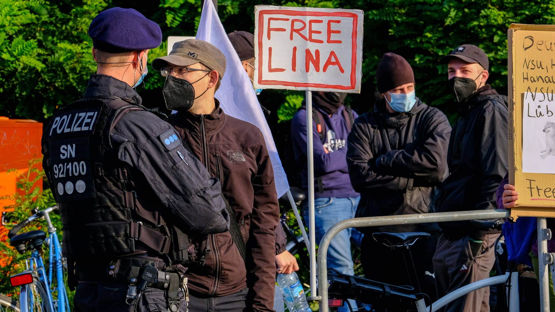 Zum Prozess-Auftakt stehen Polizisten vor Beginn eines Prozesses gegen eine Frau und drei Männer vor dem Oberlandesgericht (OLG) Dresden vor Demonstranten.