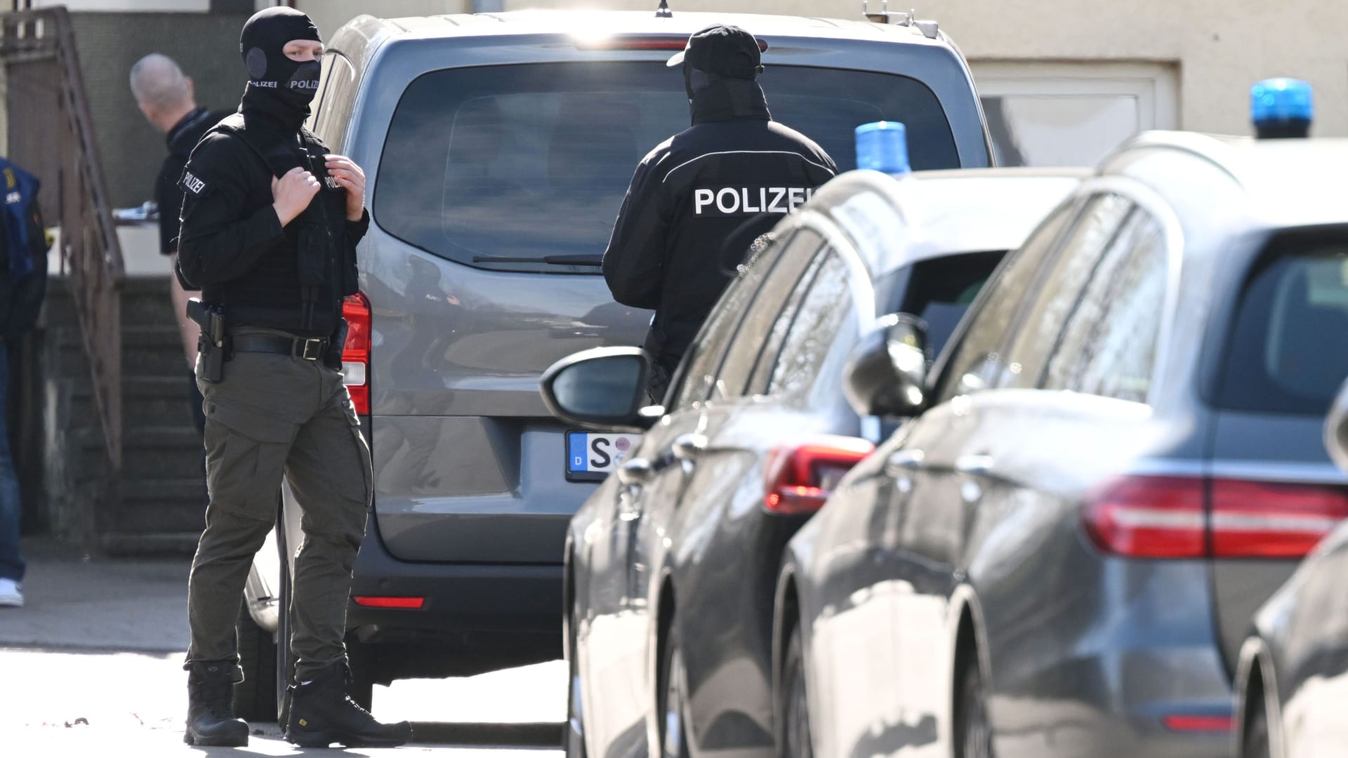 SEK-Beamte stehen zwischen Einsatzfahrzeugen in Reutlingen: Bei einer Razzia kam es zum Schusswechsel. SEK-Beamte stehen zwischen Einsatzfahrzeugen in Reutlingen: Bei einer Razzia kam es zum Schusswechsel.