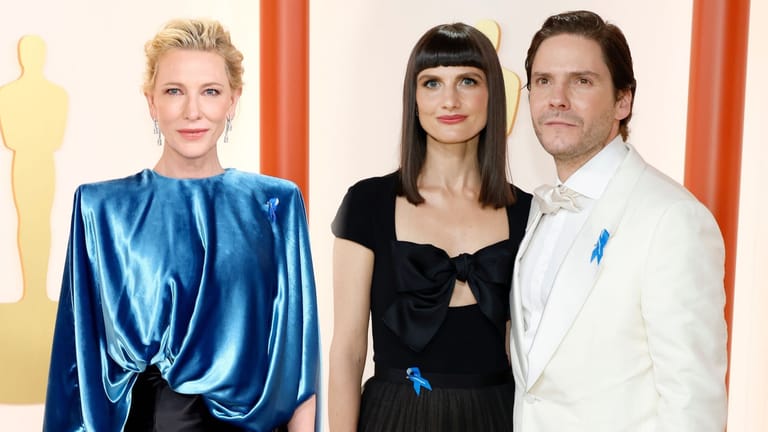 Cate Blanchett, Daniel Brühl und seine Frau Felicitas Rombold tragen eine blaue Schleife.